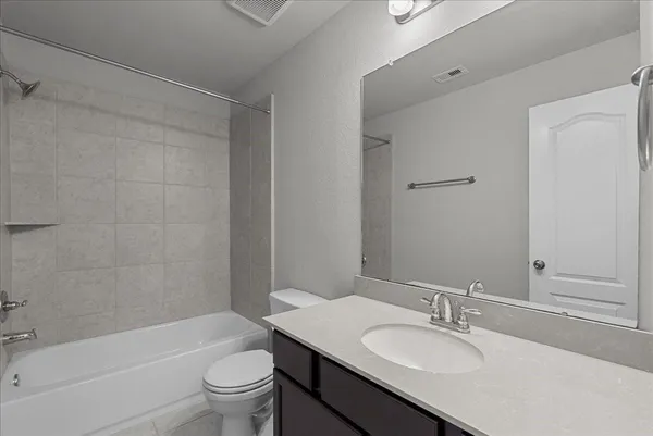 a bathroom with a granite countertop sink a toilet and shower