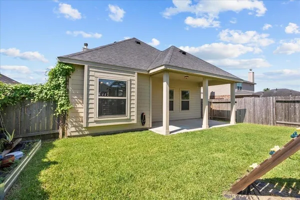 a view of a house with wooden fence next to a yard