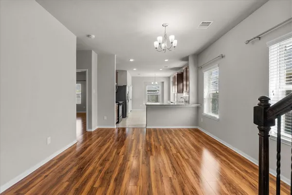 a view of a room with wooden floor staircase and a kitchen