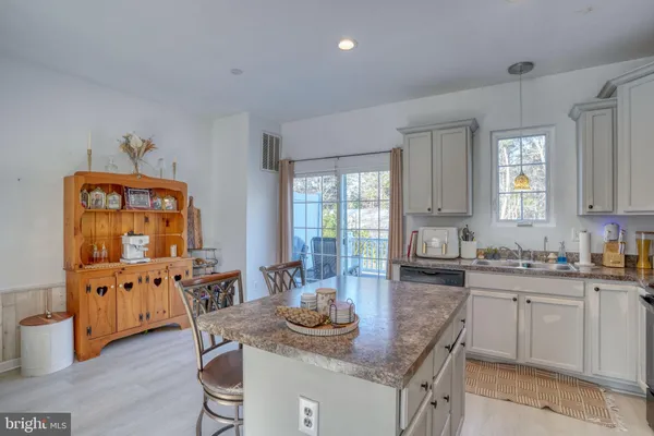 a kitchen with granite countertop a sink and cabinets