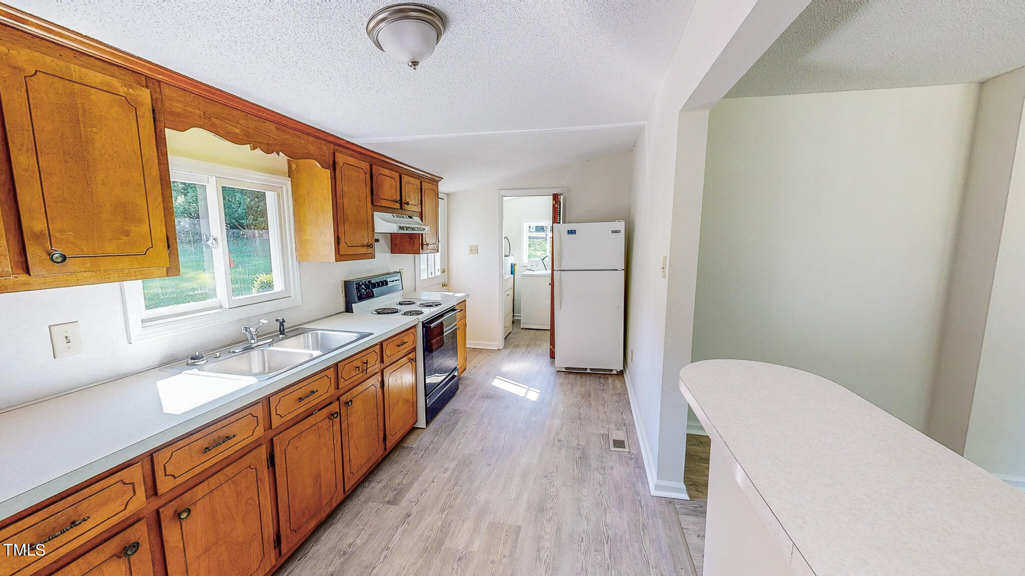 3906 Cole Mill Road Durham, NC 27712 - Photo 13 of 33 a kitchen with sink a refrigerator and wooden cabinets