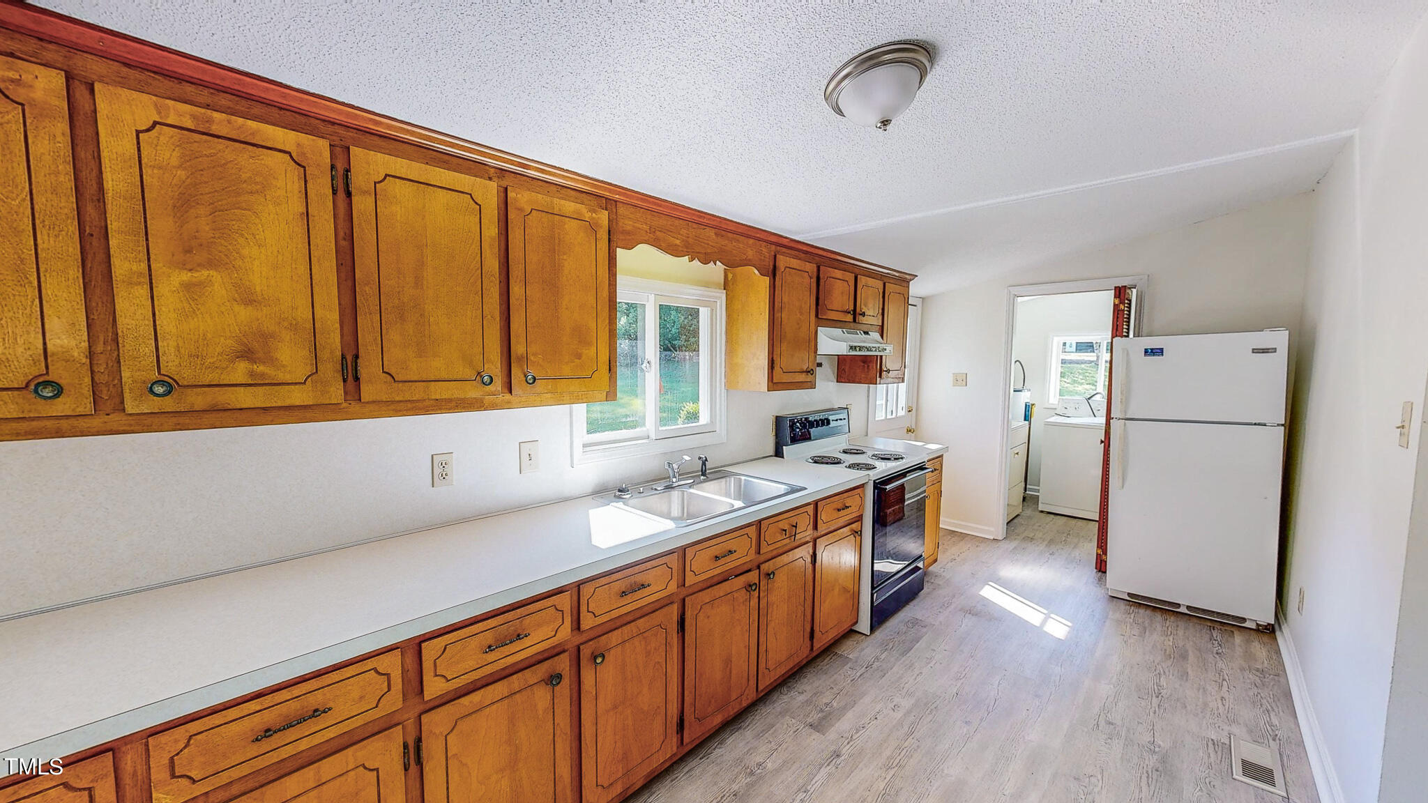 3906 Cole Mill Road Durham, NC 27712 - Photo 4 of 33 a kitchen with stainless steel appliances granite countertop a refrigerator a sink dishwasher and wooden cabinets with wooden floor