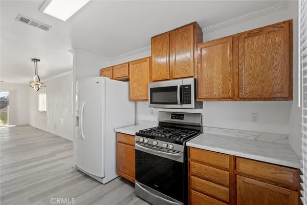 a kitchen with stainless steel appliances granite countertop a stove a refrigerator and a microwave