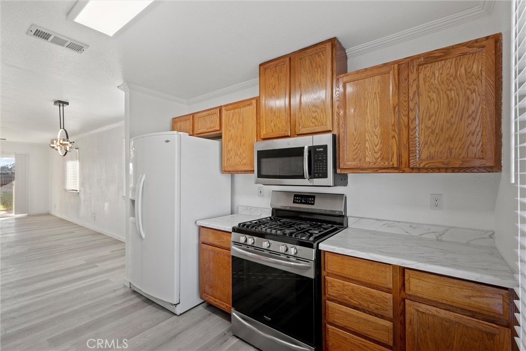2067 Blossom Avenue Corning, CA 96021 - Photo 11 of 37 a kitchen with stainless steel appliances granite countertop a stove a refrigerator and a microwave