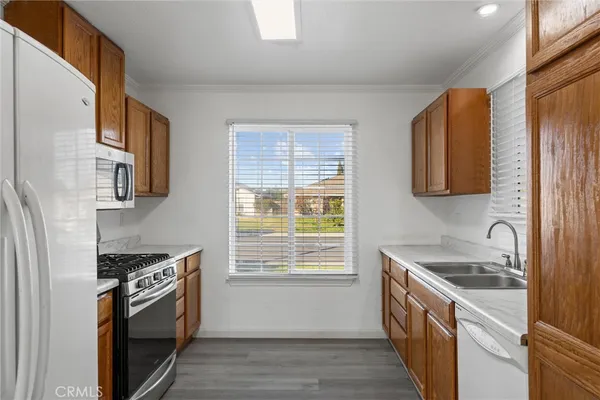 a kitchen with a sink cabinets stainless steel appliances and a window