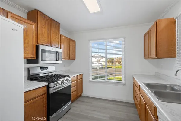 a kitchen with stainless steel appliances granite countertop a stove a sink and a microwave