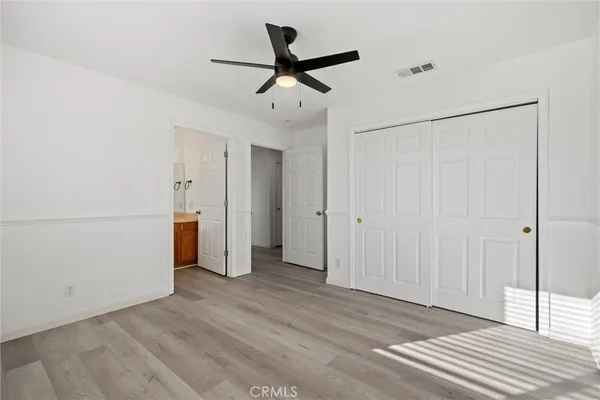 a view of a livingroom with a ceiling fan & entryway