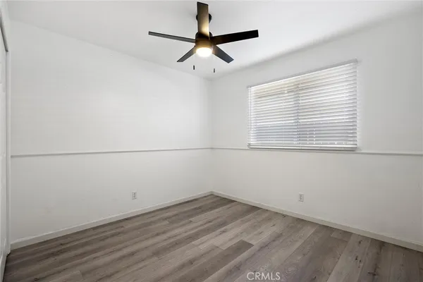an empty room with a window and a ceiling fan