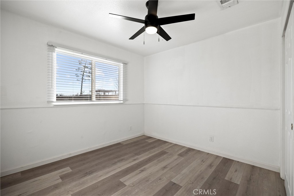 2067 Blossom Avenue Corning, CA 96021 - Photo 19 of 37 an empty room with wooden floor and windows