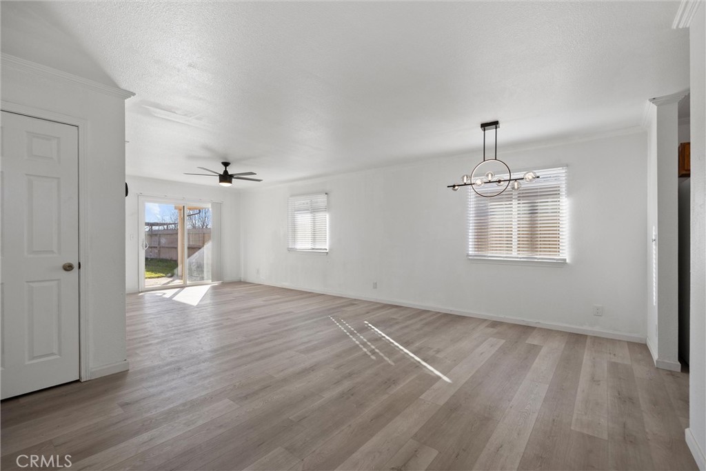 2067 Blossom Avenue Corning, CA 96021 - Photo 5 of 37 an empty room with wooden floor chandelier and windows