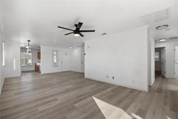 a view of a livingroom with wooden floor and a ceiling fan