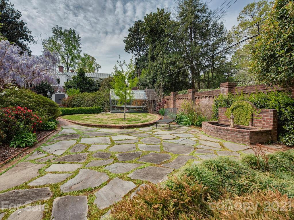 1600 Queens Road Charlotte, NC 28207 - Photo 23 of 30 a view of a backyard with plants and a fountain