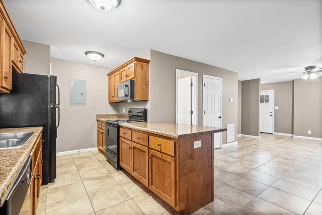 a kitchen with stainless steel appliances granite countertop a sink and a refrigerator