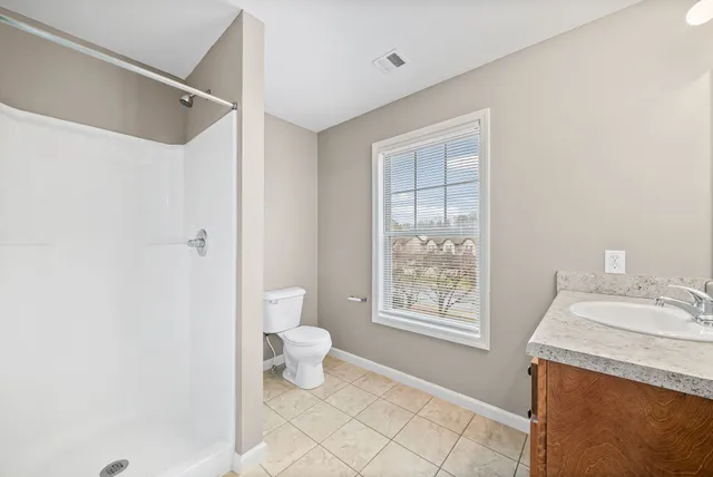a bathroom with a granite countertop sink a toilet and a mirror