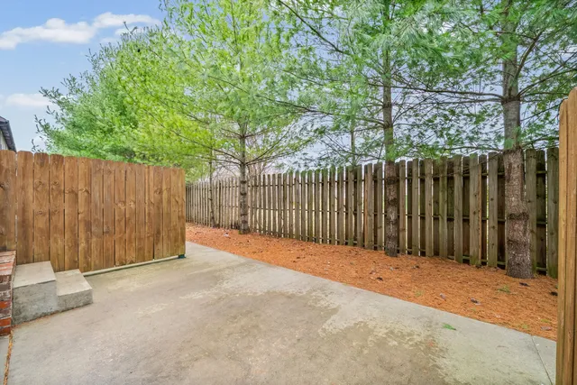 a view of a patio with table and chairs with wooden fence