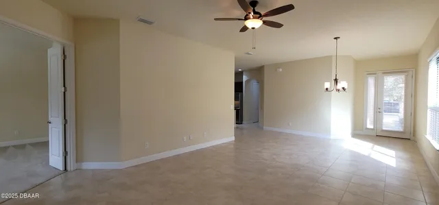 a view of a big room with a chandelier fan and windows