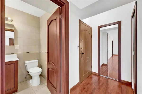 a bathroom with a granite countertop toilet a sink and a mirror