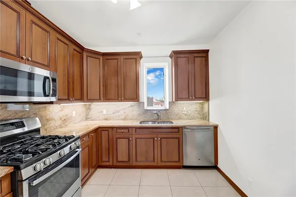 a kitchen with stainless steel appliances granite countertop a stove a sink and a microwave
