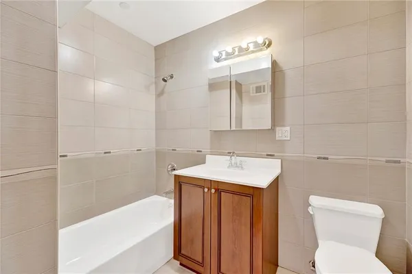 a bathroom with a sink toilet vanity and bathtub