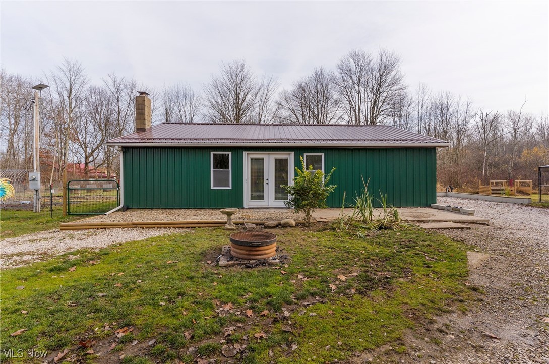 6590 Hall Road Andover, OH 44003 - Photo 3 of 29 View of front of home with a fire pit, a chimney, french doors, and a metal roof