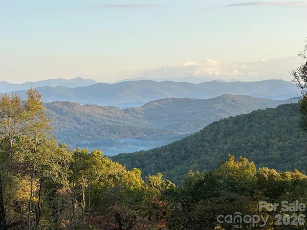 a view of mountain with sunset in background