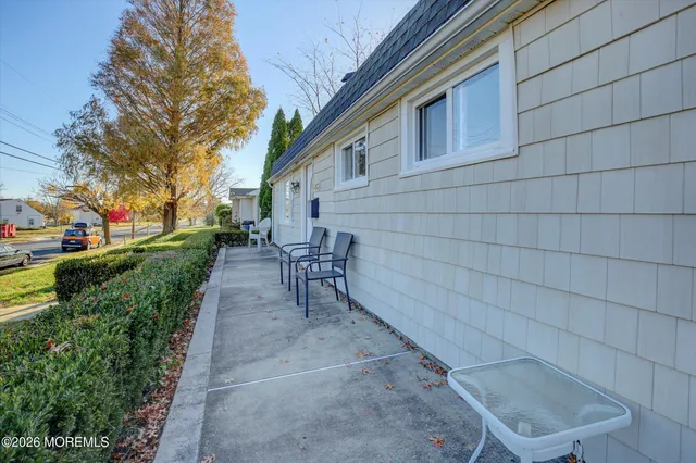 a view of a patio with a bench and trees