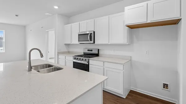 a kitchen with granite countertop white cabinets and stainless steel appliances