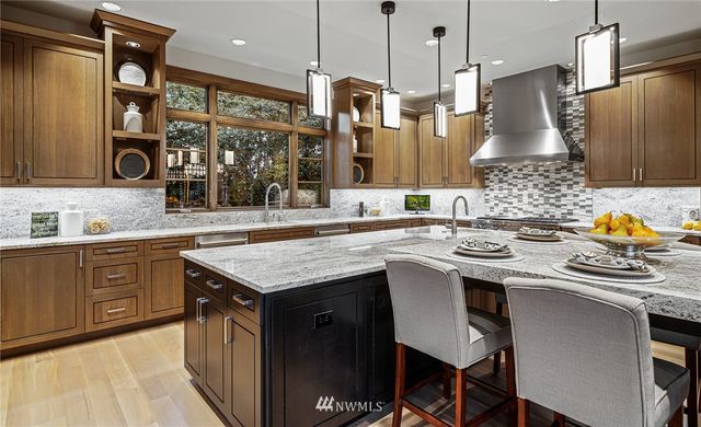 a kitchen with stainless steel appliances granite countertop a sink a stove and a wooden floors