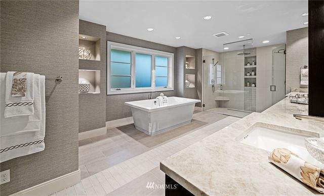 a spacious bathroom with a tub sink and mirror