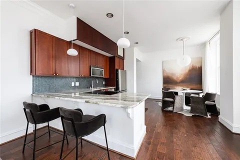 a kitchen with kitchen island granite countertop a table chairs microwave and cabinets