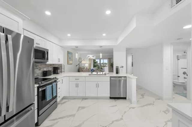 a kitchen with white cabinets stainless steel appliances and a counter space