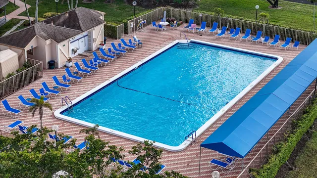 an aerial view of a tennis ground and a cars park side of the road