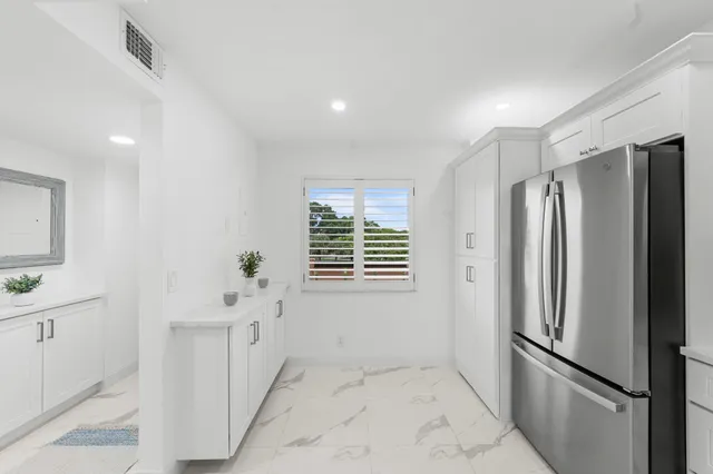 a view of kitchen with furniture and refrigerator