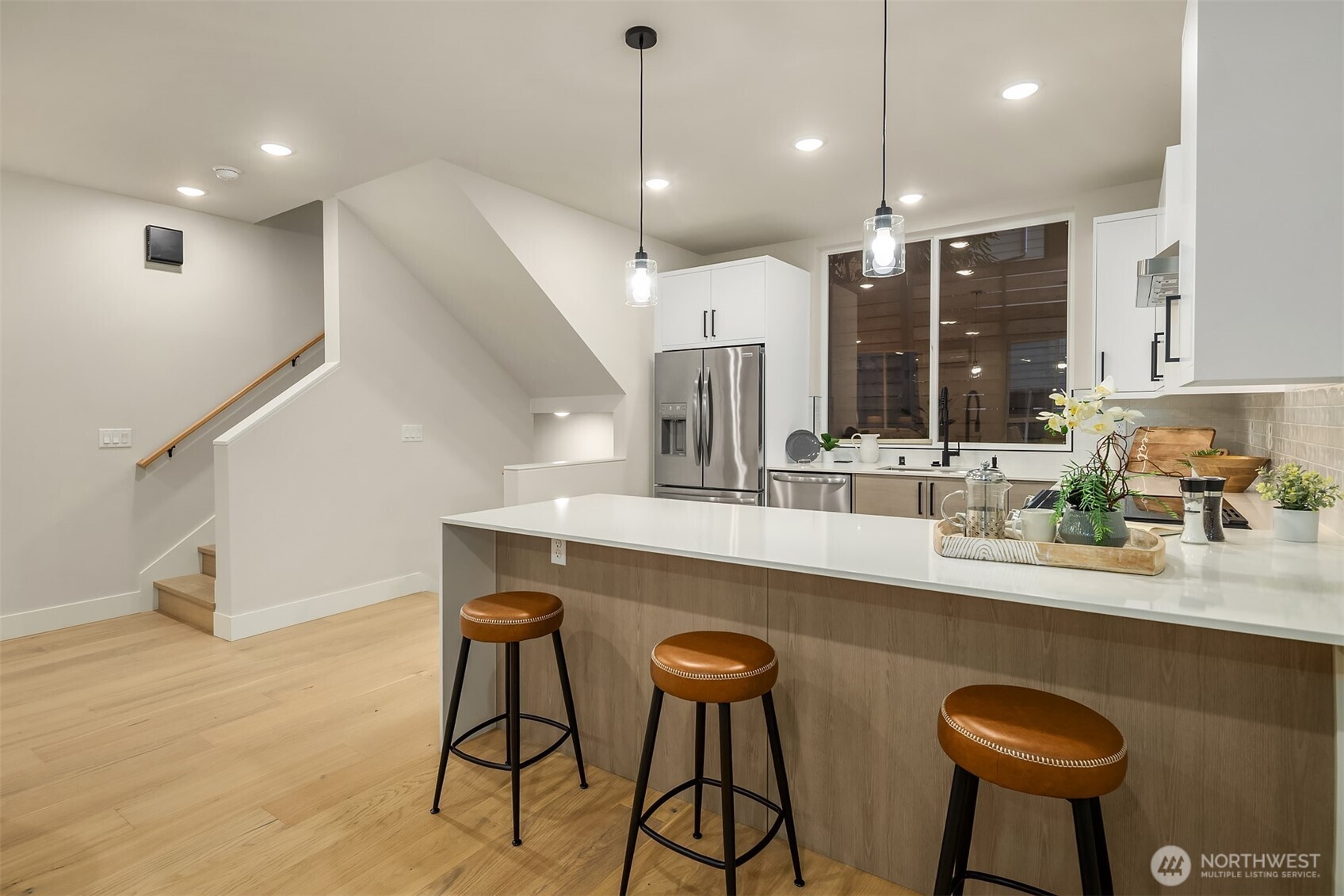1313 14th Avenue South, Unit B Seattle, WA 98144 - Photo 10 of 30 a kitchen with stainless steel appliances granite countertop a sink a stove a refrigerator a dining table and chairs with wooden floor
