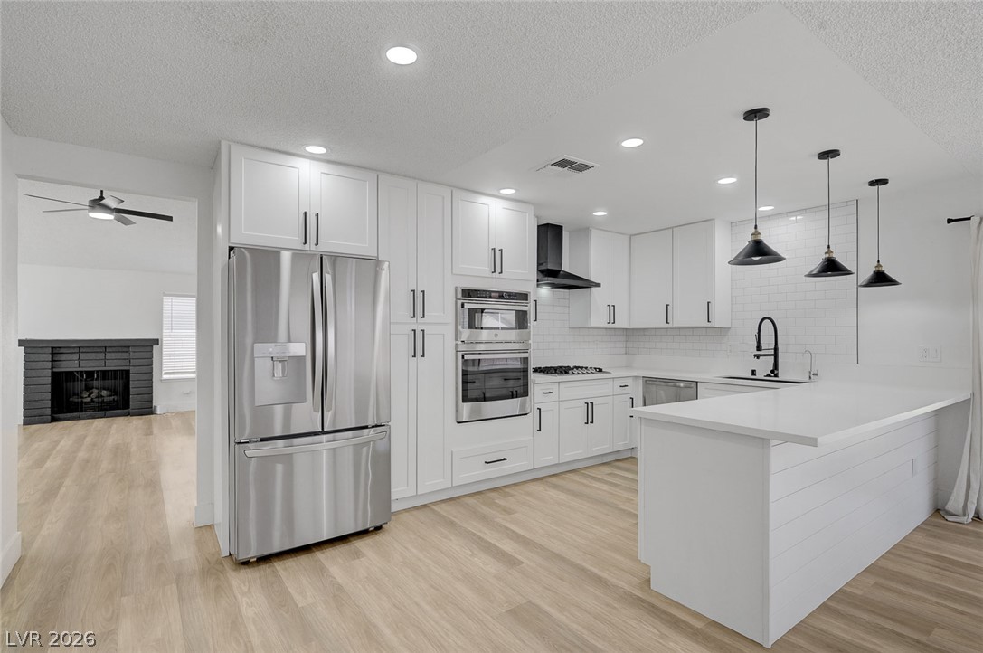 4840 Summerhill Road Las Vegas, NV 89121 - Photo 14 of 56 White cabinetry, stainless steel appliances, and a central island define this modern kitchen.