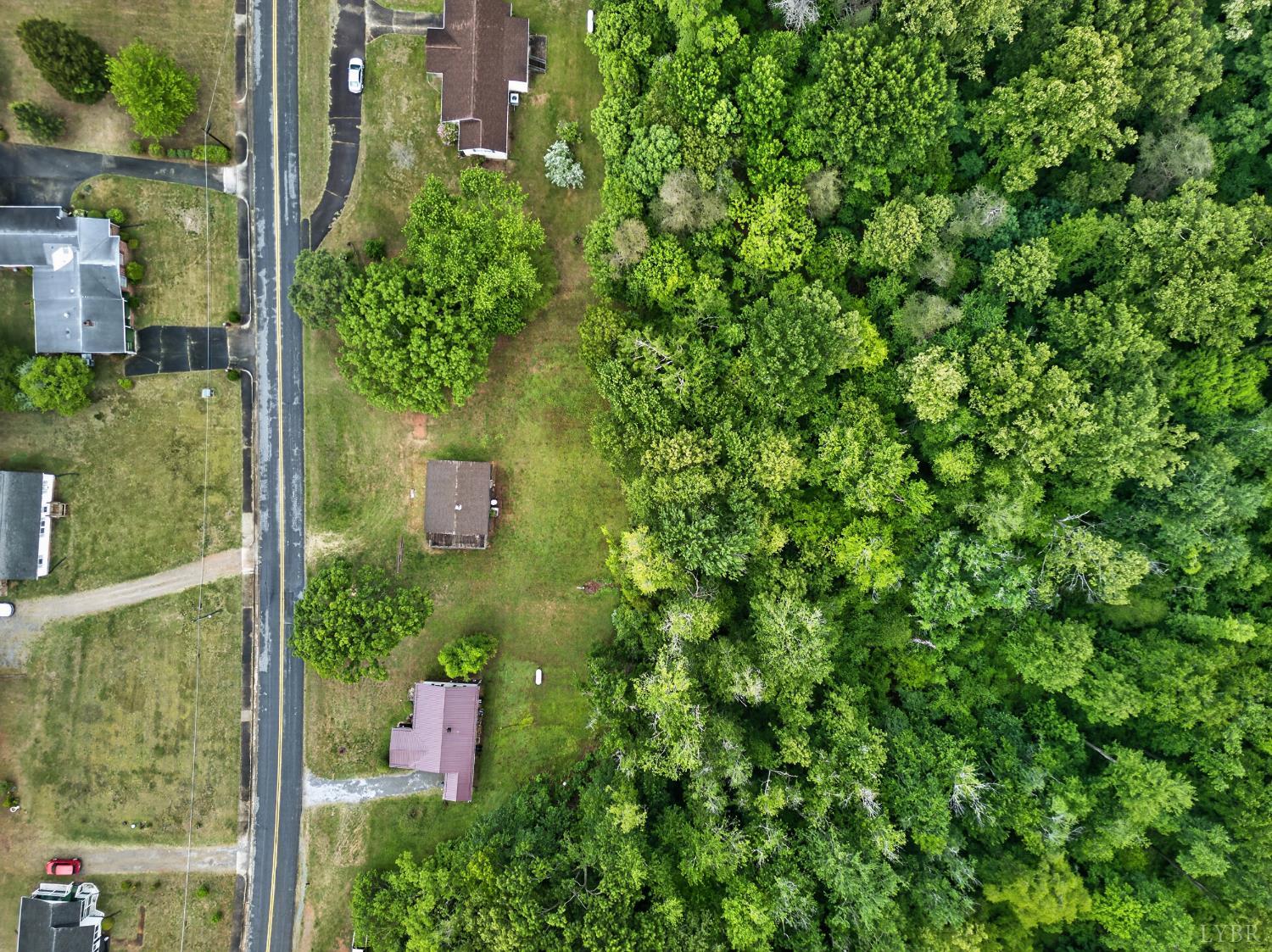 312 Cheney Lane Gretna, VA 24557 - Photo 15 of 16 a backyard of a house with lots of green space and tree in the back