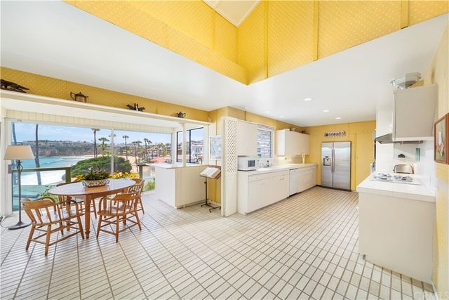 a large white kitchen with a stove top oven a sink and dishwasher