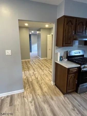 a kitchen with granite countertop a stove a sink and a refrigerator