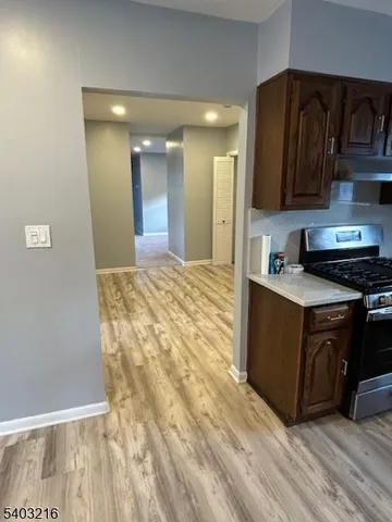 a kitchen with granite countertop a stove a sink and a refrigerator