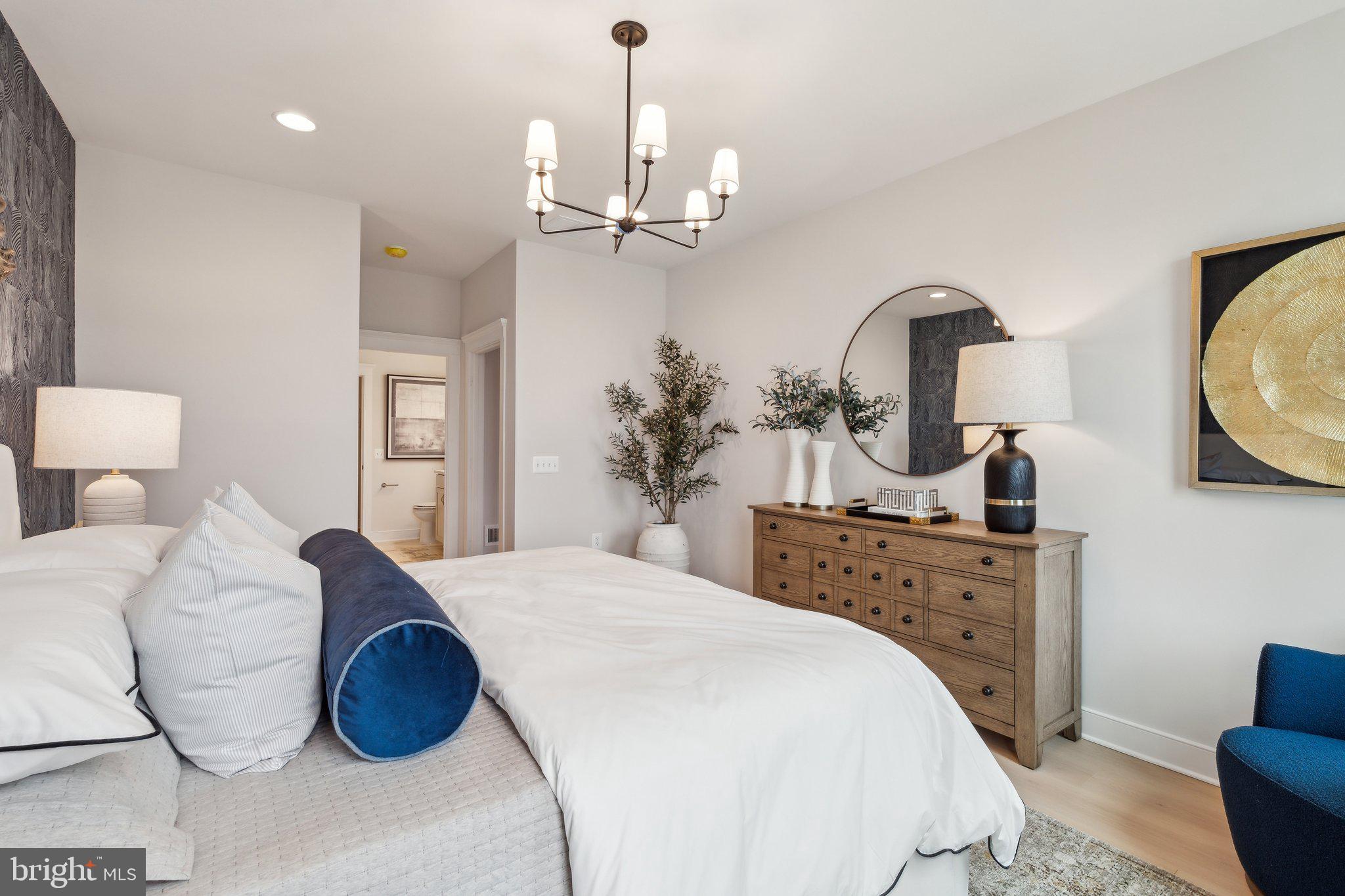 410 Granite Rdg Drive Winchester, VA 22603 - Photo 20 of 27 a spacious bedroom with a bed a chandelier and mirror
