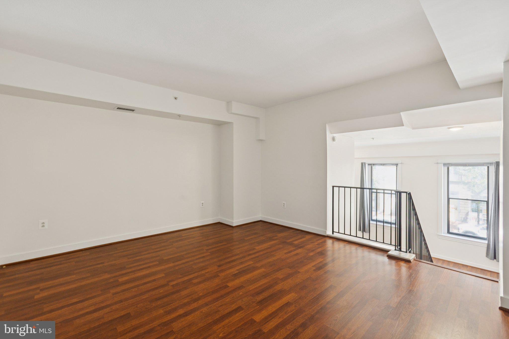 616 E Street Northwest, Unit 217 Washington, DC 20004 - Photo 21 of 73 a view of an empty room with wooden floor and fence