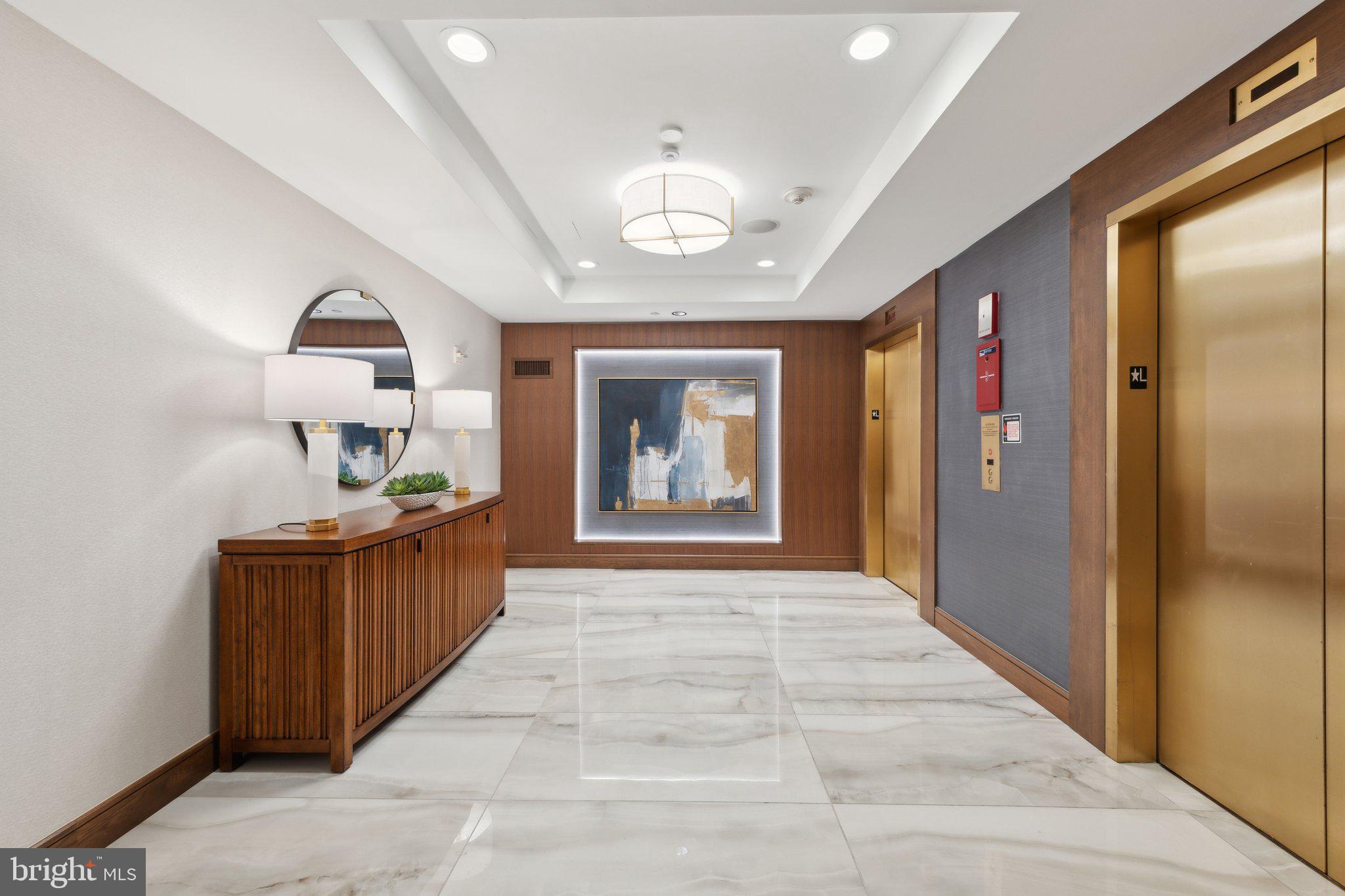 616 E Street Northwest, Unit 217 Washington, DC 20004 - Photo 35 of 73 a view of a hallway to a livingroom with furniture cabinet mirror and window