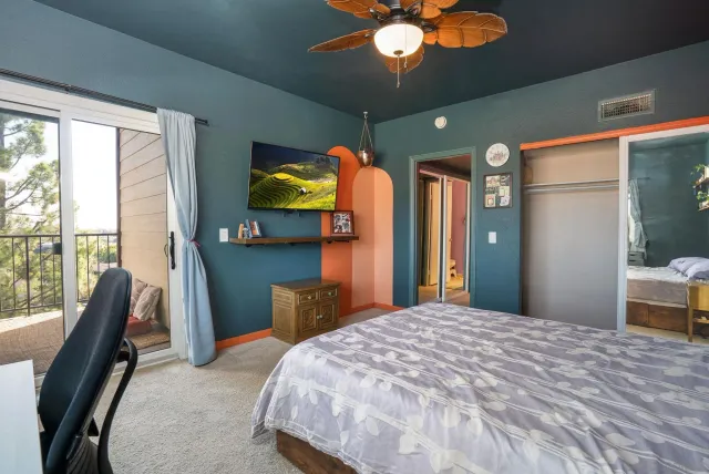 a bedroom with a bed dresser and a large window