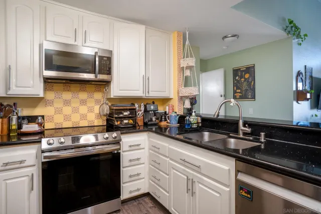 a kitchen with stainless steel appliances granite countertop a sink stove and microwave
