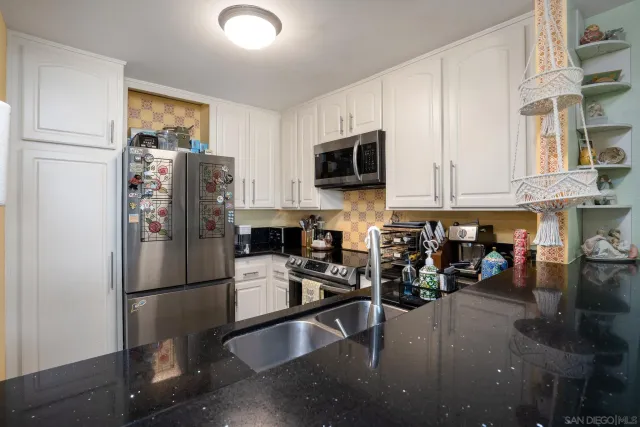 a kitchen with stainless steel appliances granite countertop a refrigerator stove microwave and sink