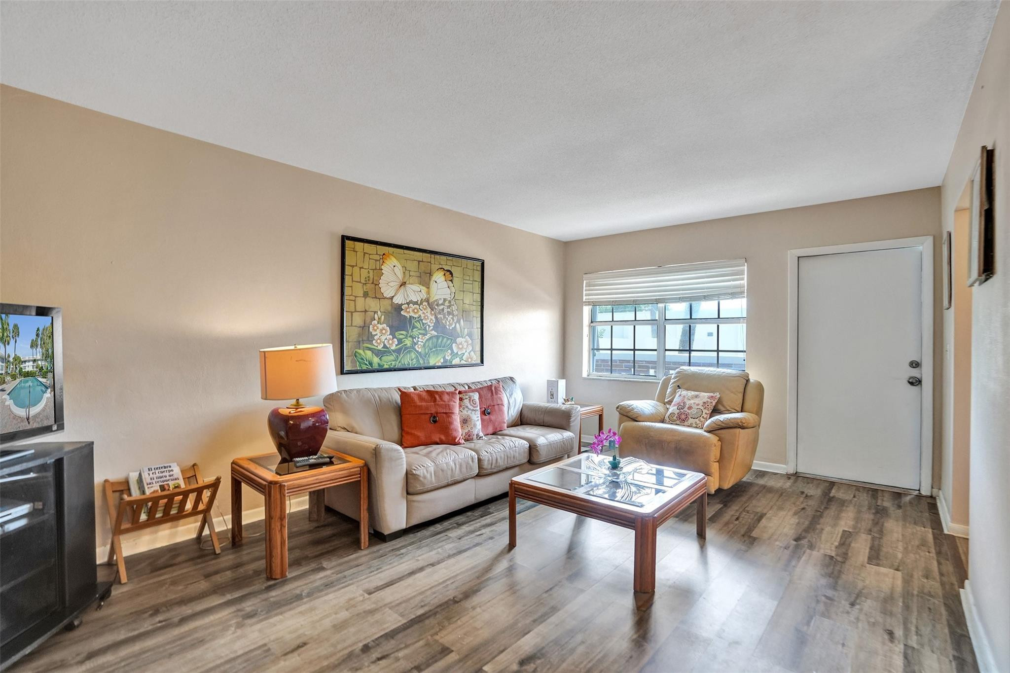 a living room with furniture a wooden floor and a window