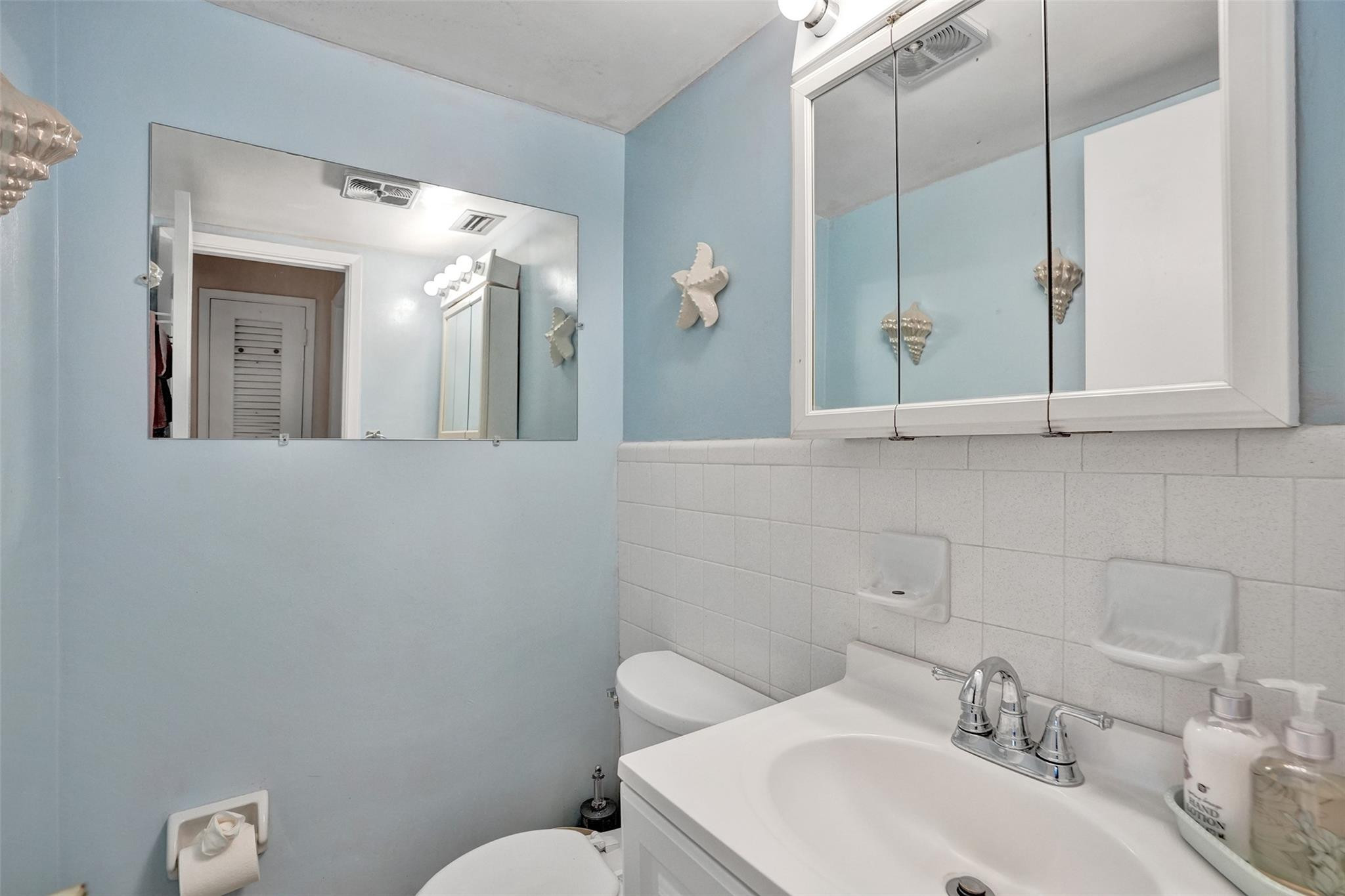 2050 Northeast 39th Street, Unit 203S Lighthouse Point, FL 33064 - Photo 5 of 16 a bathroom with a sink mirror and toilet