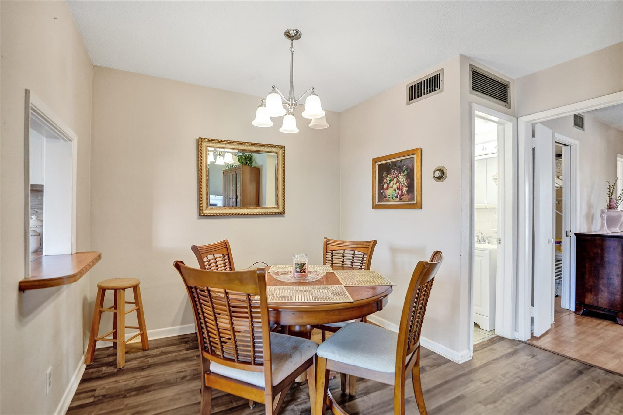 2050 Northeast 39th Street, Unit 203S Lighthouse Point, FL 33064 - Photo 10 of 16 a view of a dining room with furniture wooden floor and a chandelier