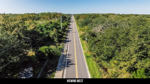 a view of a green field with lots of bushes