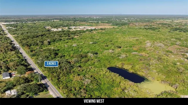 a view of a green field with lots of bushes